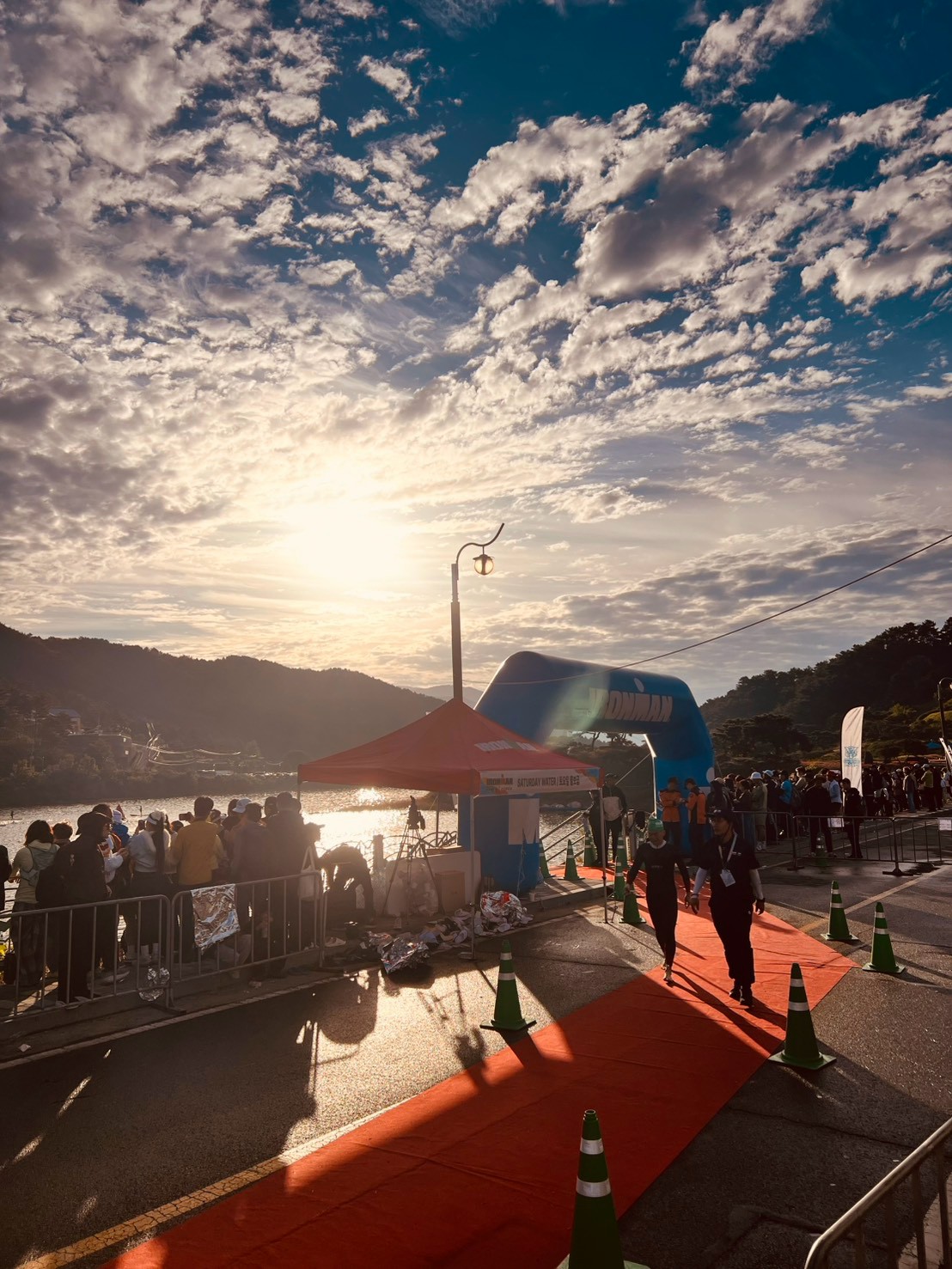 湖畔 IRONMAN 拱門、紅色通道與穿防寒衣的選手