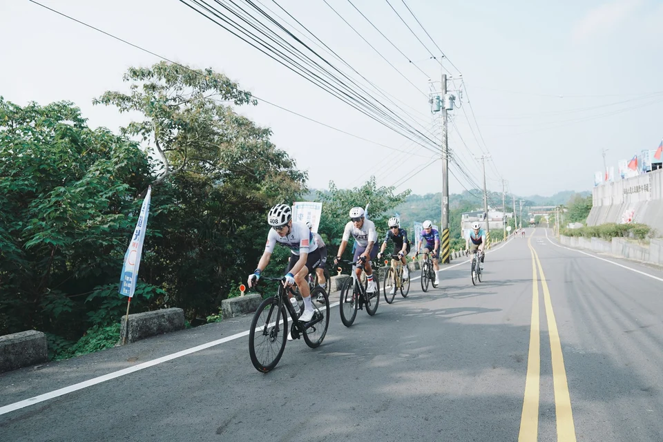 自行車選手沿著南庄山路騎行,山谷與林木在道路兩側展開